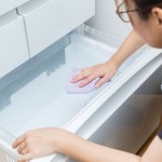 冷蔵庫の拭き掃除をする女性