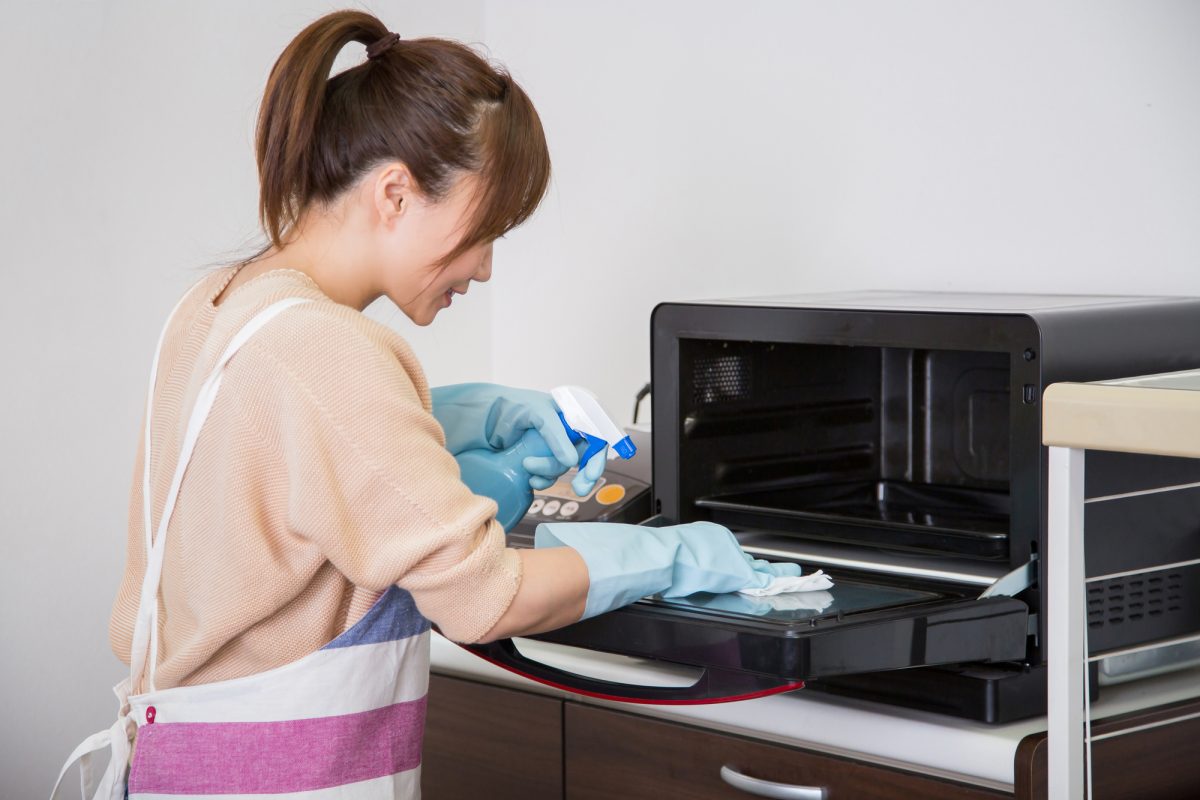 電子レンジを掃除する女性